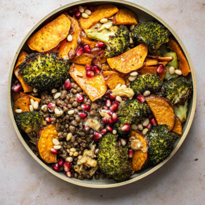 A broccoli and sweet potato lentil bowl with pomegranate seeds.