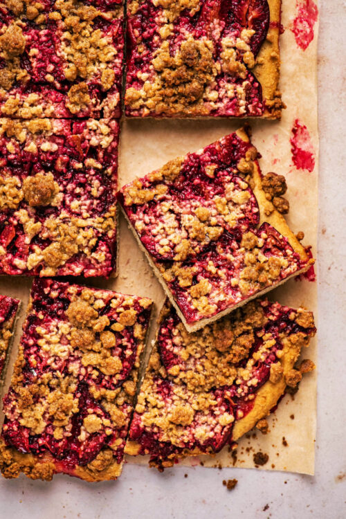 Plum streusel cake cut into squares, top down view.