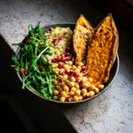 A roasted sweet potato bowl with quinoa, chickpeas, and greens.