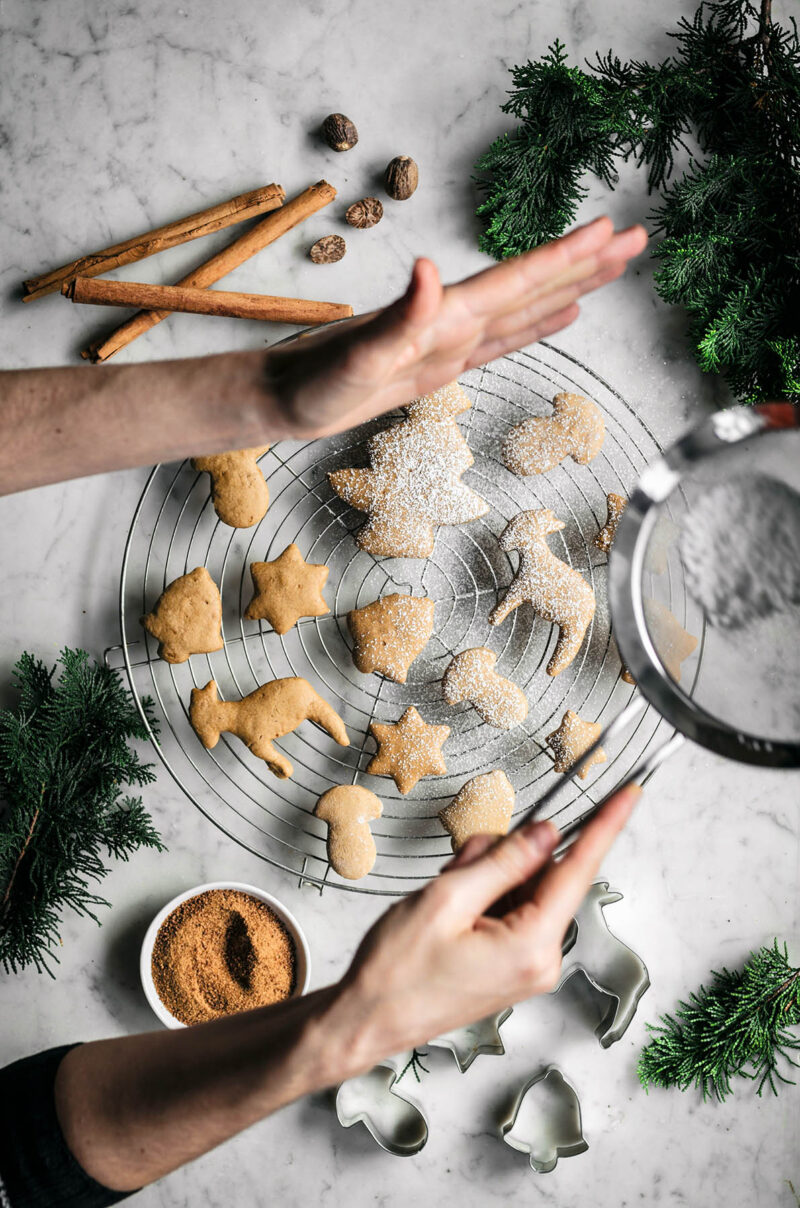 Sprinkling coconut flour onto the baked cookies.