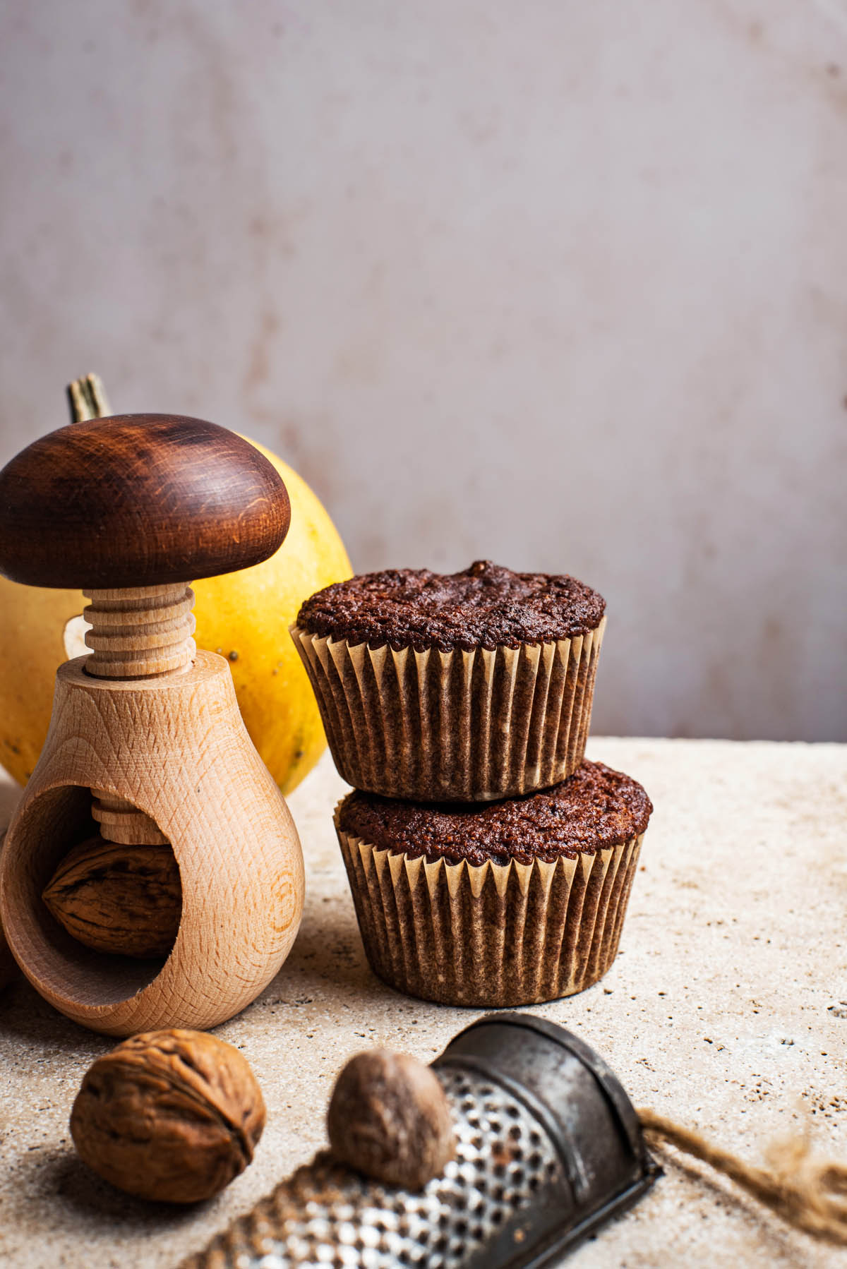Two muffin stacked with a mushroom nutcracker and nutmeg grater.