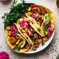Three potato tacos in a shallow bowl.