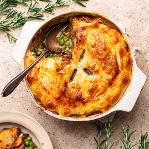 Mushroom pot pie with a serving on a separate plate.