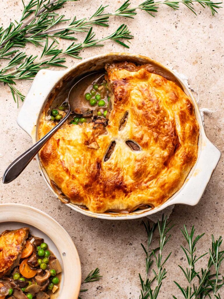 Mushroom pot pie with a serving on a separate plate.