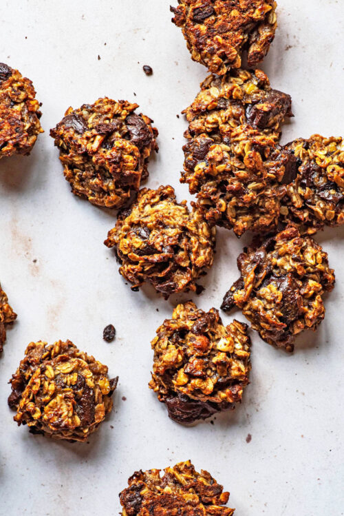 Several oat cookies with chocolate on a light background.