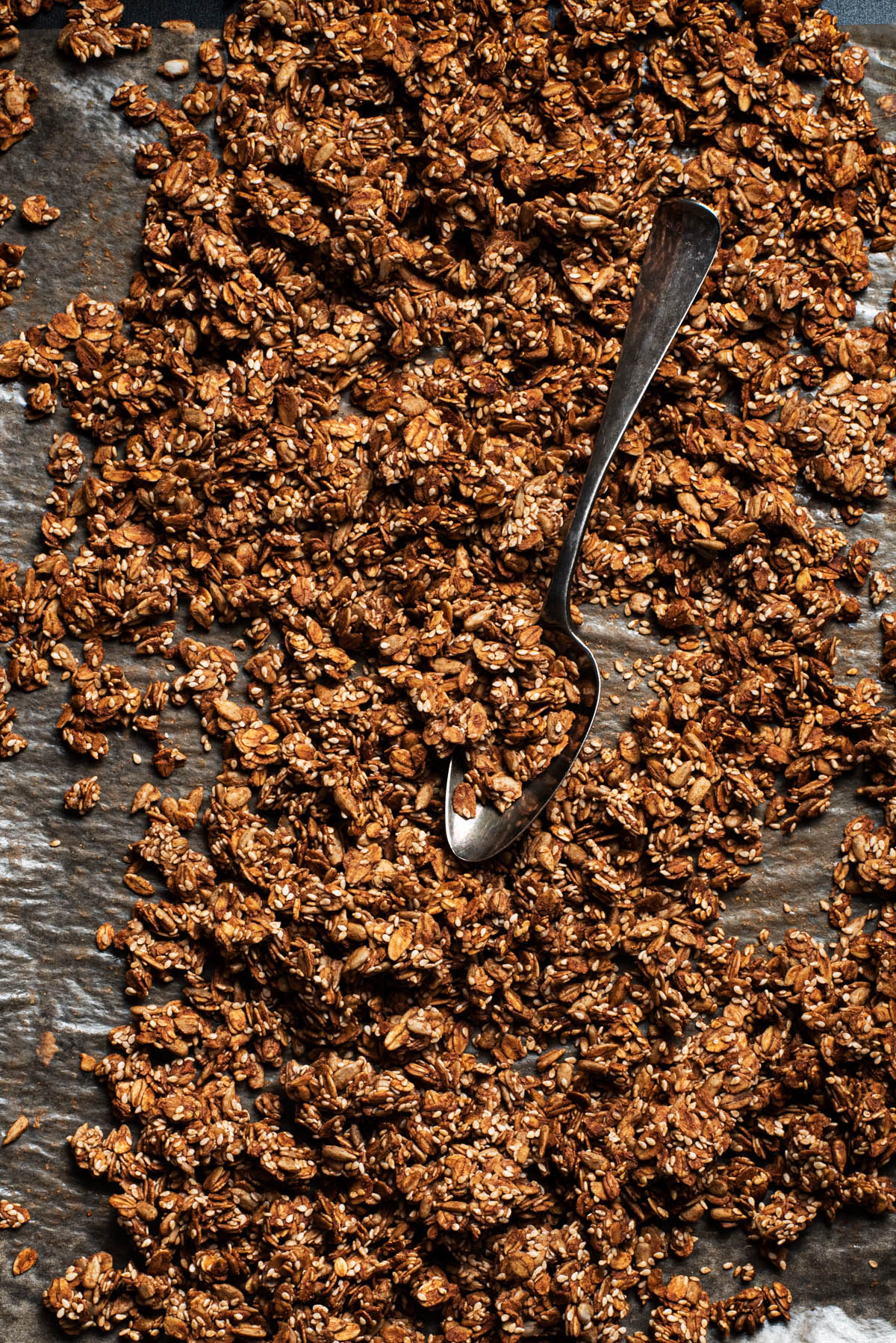 Close up of a tray of granola with an old spoon.