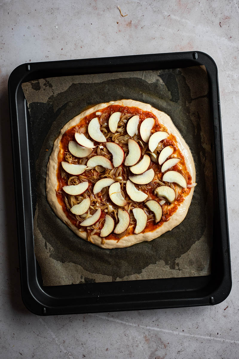 Apples added to the pizza.