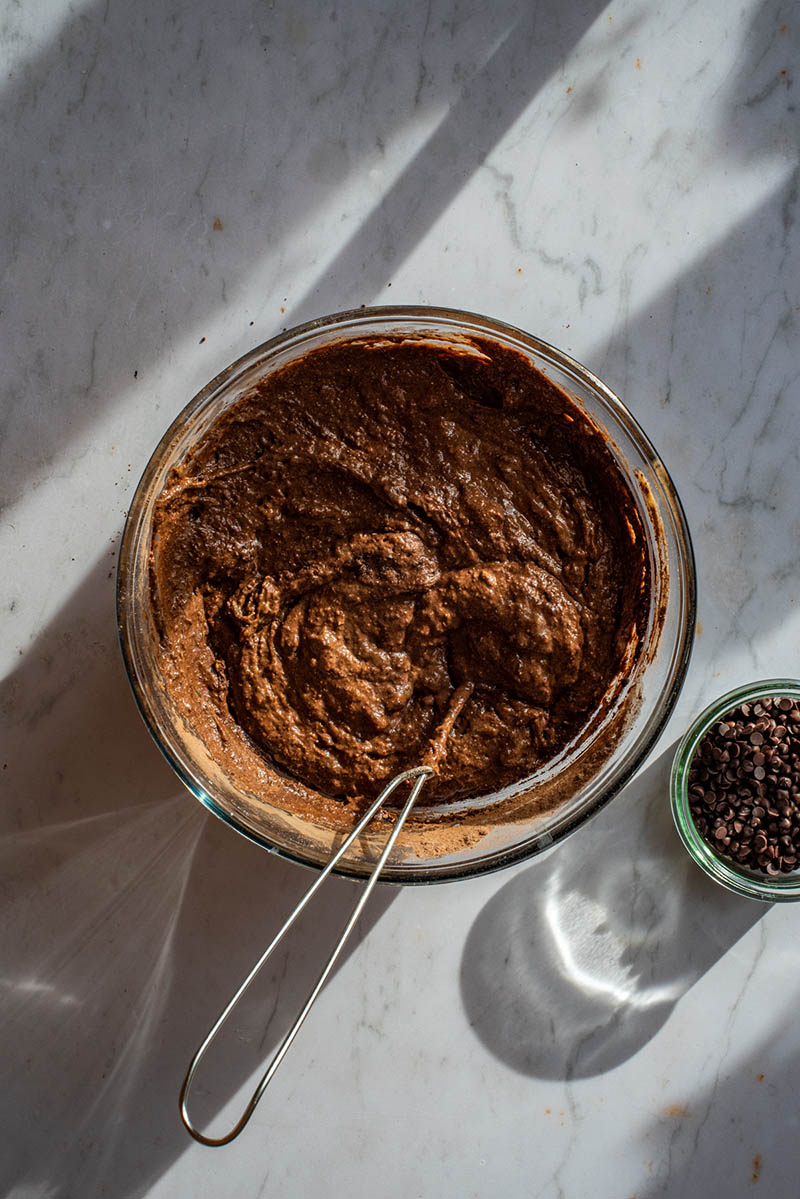 Thick chocolate cake batter in a glass bowl.