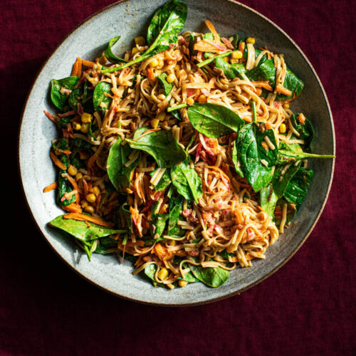 Peanut butter noodle bowl in a large ceramic serving dish.