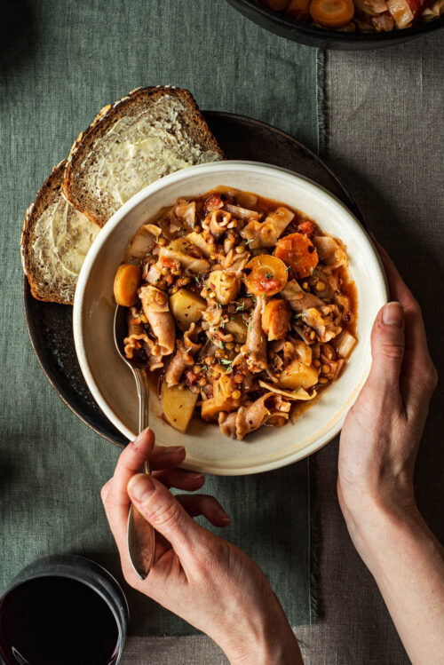 Woman's hands holding a bowl of cabbage soup.