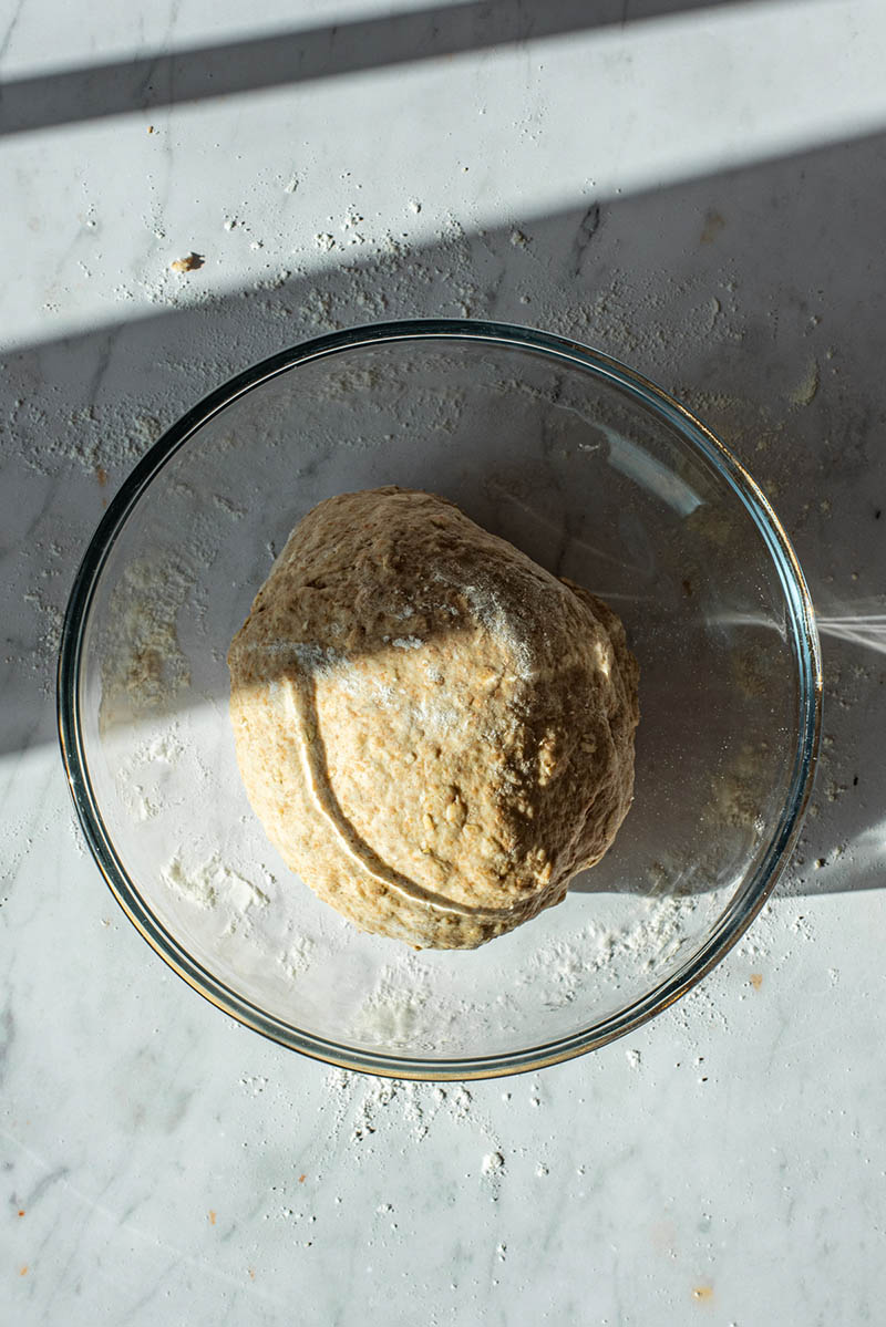 Kneaded dough placed into a glass bowl.