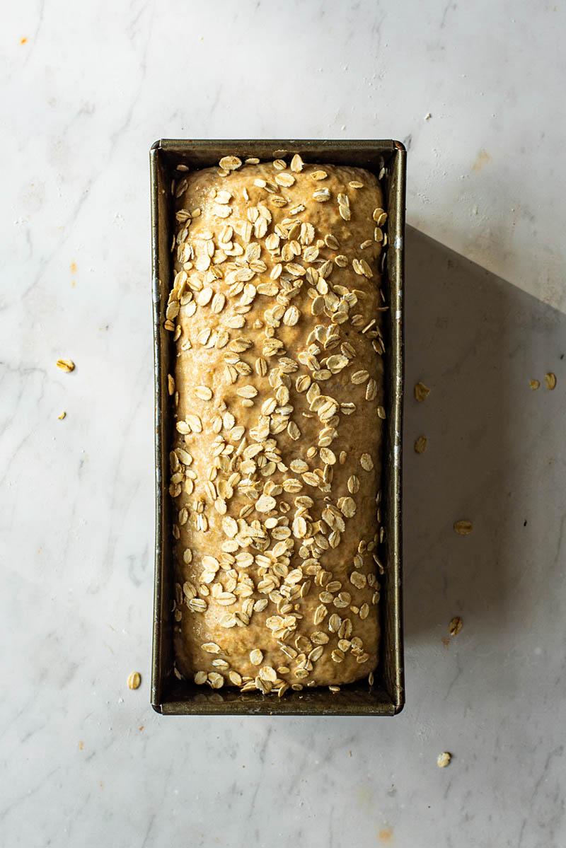 Bread topped with oats before baking.