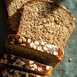 Oat bread with several slices cut, top down view.