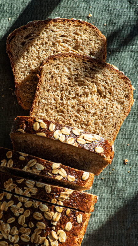 Oat bread with several slices cut, top down view.