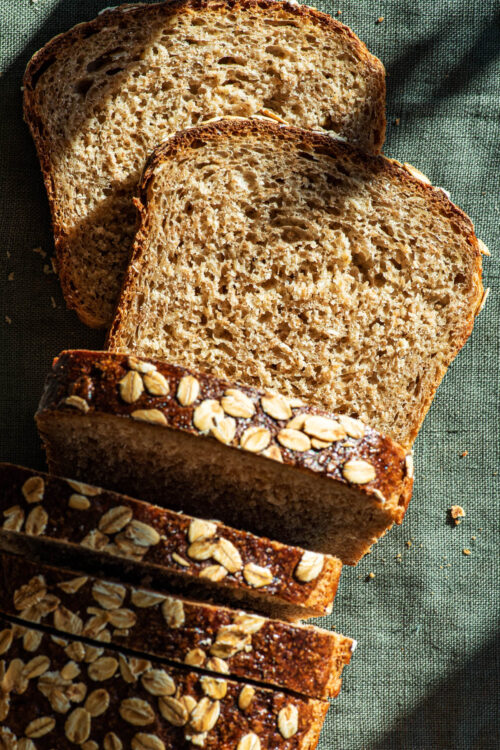 Oat bread with several slices cut, top down view.
