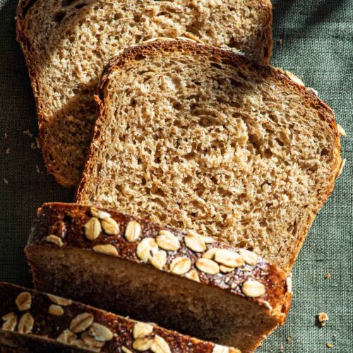 Oat bread with several slices cut, top down view.