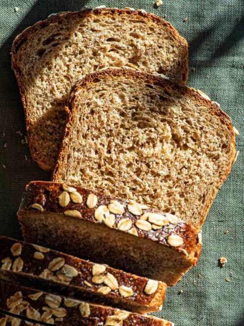 Oat bread with several slices cut, top down view.