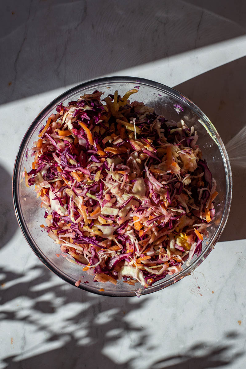Mixed coleslaw in a glass bowl.