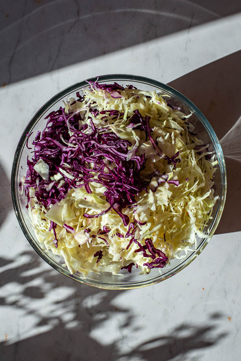 Cabbage and other vegetables in a glass bowl.