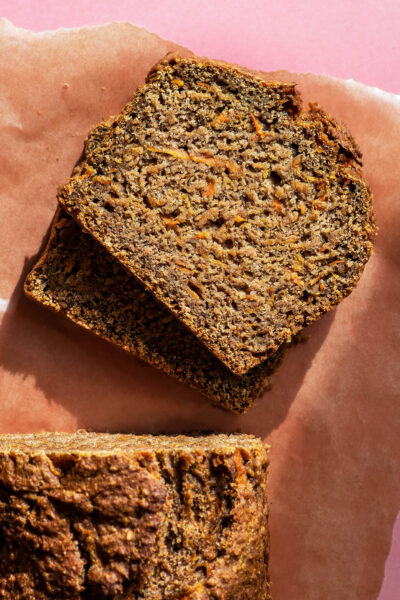 Carrot bread with two slices cut, on parchment paper.