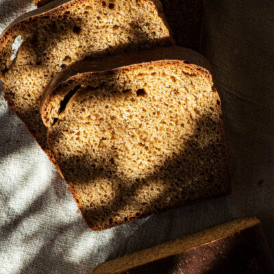 Einkorn bread, sliced, in dappled light.
