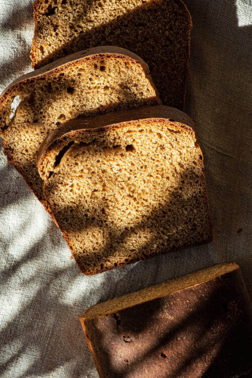 A loaf of bread, partly sliced, top down view.