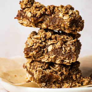 Three date squares stacked on a small plate.