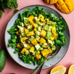 Mango salad on a bed of lamb's lettuce in a large bowl.