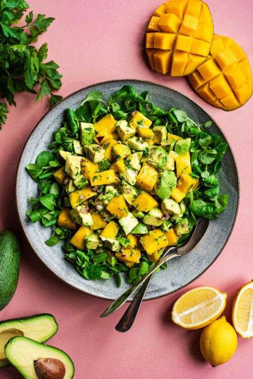 Mango salad on a bed of lamb's lettuce in a large bowl.