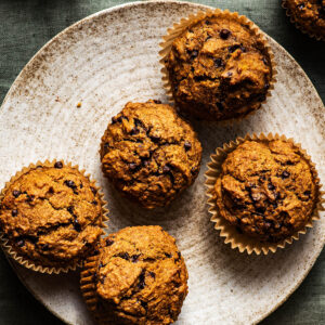 Several pumpkin muffins on a plate.