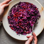 Finely chopped roasted red cabbage on a plate with pomegranate seeds.