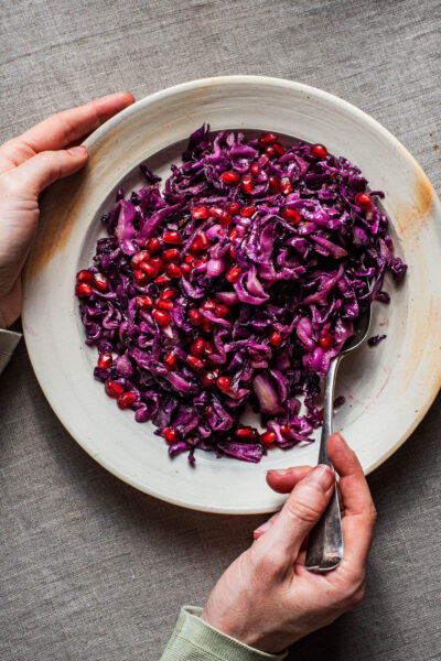 Finely chopped roasted red cabbage on a plate with pomegranate seeds.