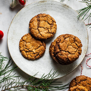Ginger nuts on a plate with greenery around.