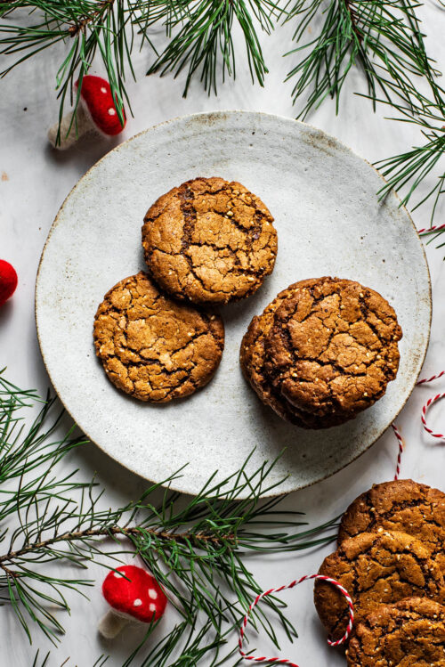 Ginger nuts on a plate with greenery around.
