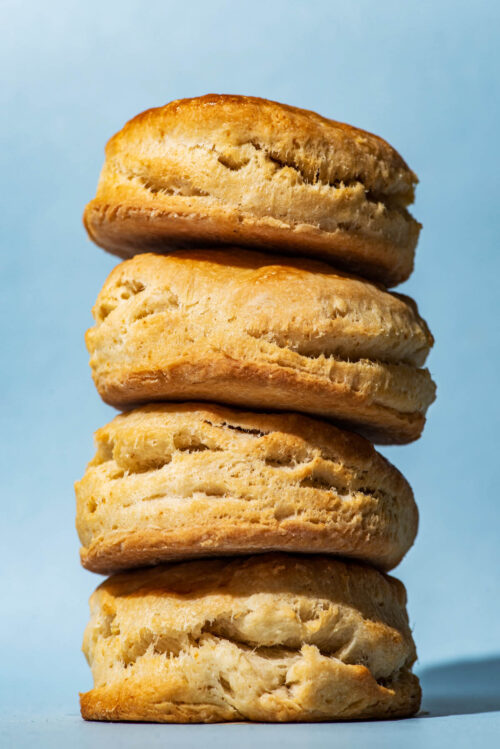 A stack of four vegan coconut oil biscuits with a blue background.