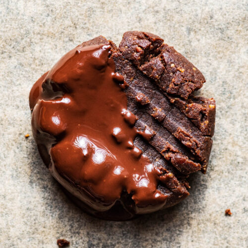 Close up of a chocolate cookie dipped in melted chocolate.