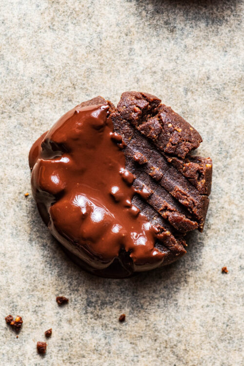 Close up of a chocolate cookie dipped in melted chocolate.