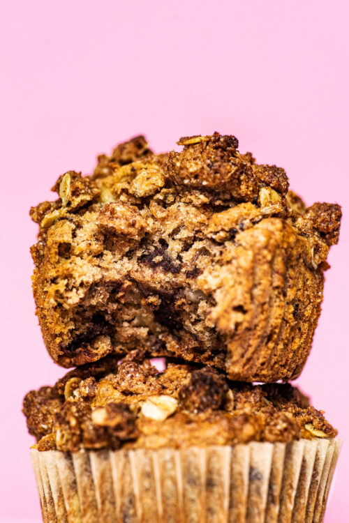 Close up of two muffins, stacked, with a bite taken out of the top muffin.