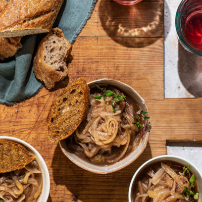 Three small bowls of French onion soup with small toasts.