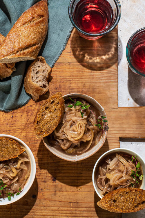 Three small bowls of French onion soup with small toasts.