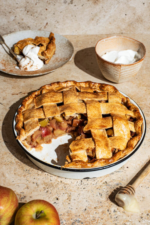 Apple pie three-quarters view, with a slice removed to show the filling.