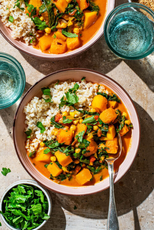 Top-down view of a winter squash curry in bowls with rice.