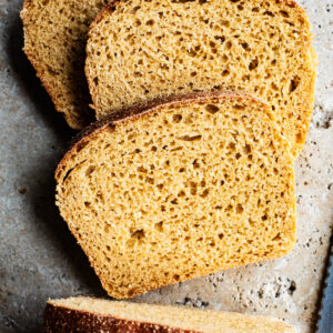 Three slices of bread from a loaf, top down view.