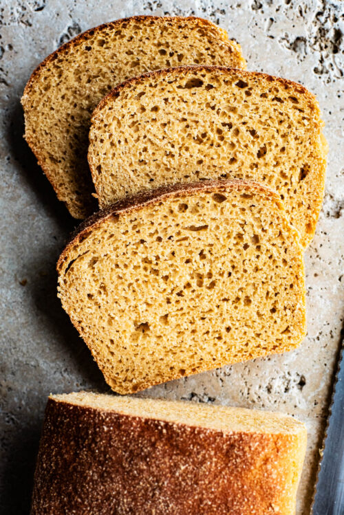 Three slices of bread from a loaf, top down view.