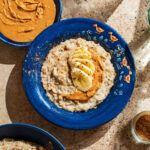 A bowl of porridge topped with banana and peanut butter.