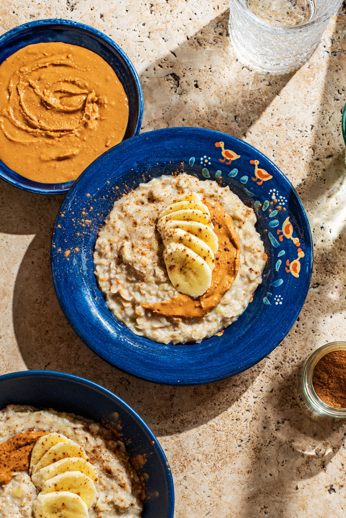 A bowl of porridge topped with banana and peanut butter.
