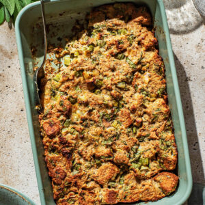 Top-down view of a rectangular dish of bread stuffing with a scoop removed.