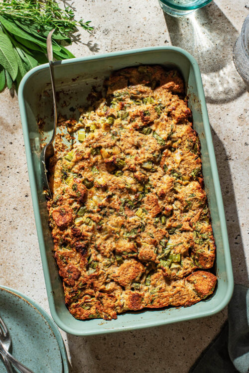 Top-down view of a rectangular dish of bread stuffing with a scoop removed.