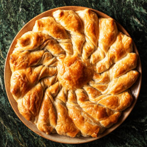Round pull-apart pastry on a plate on green marble.