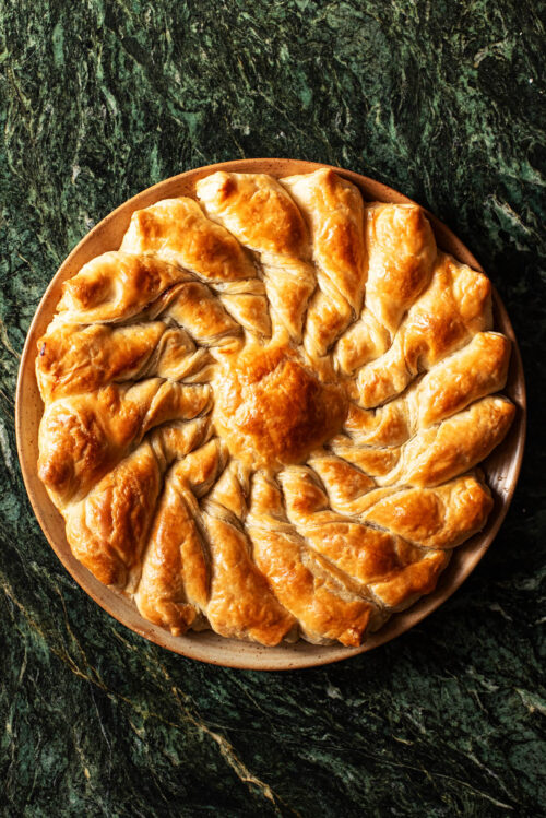 Round pull-apart pastry on a plate on green marble.